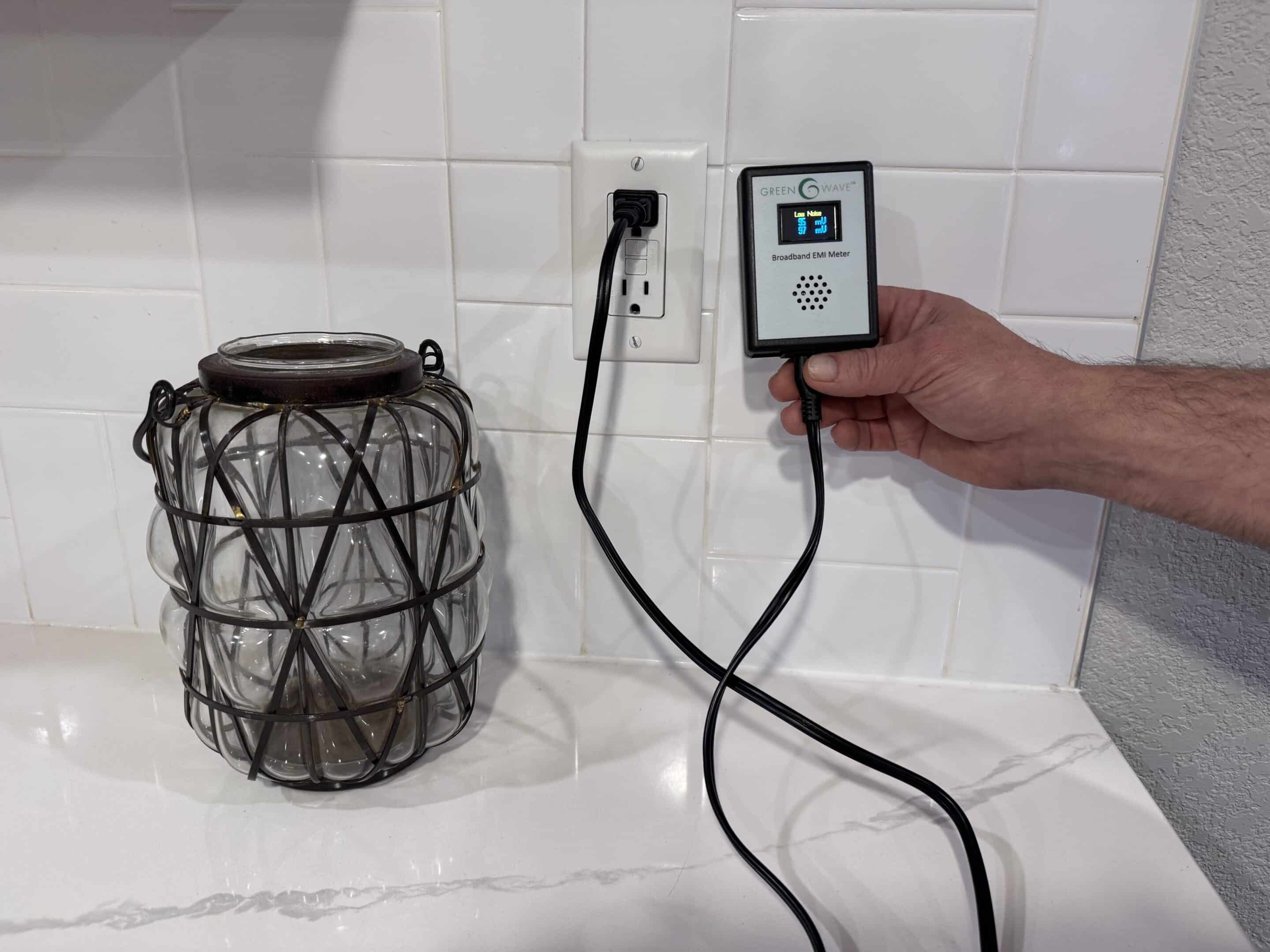 Phot of Greenwave Broadband EMI Meter plugged into electrical outlet